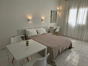 a bedroom with a bed and a table and chairs at Aktio Studios in Gavrio