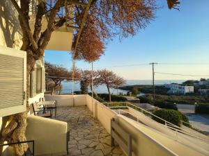 a balcony of a house with a tree at Aktio Studios in Gavrio