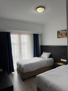 a hotel room with two beds and a window at The Yücedağ Hotel in Arapkir