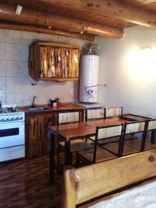 a kitchen with wooden cabinets and a table and a stove at Cabañas Kay Hue in San Carlos de Bariloche +99 photos