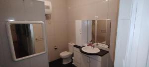 a bathroom with a sink and a toilet and a mirror at Mycoffee Apartment in Mindelo