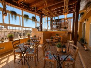 a restaurant with tables and chairs in a room with windows at Suites Sangiovanni in Ragusa