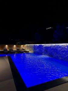 a swimming pool at night with a water fountain at Hotel Utopia in Ksamil