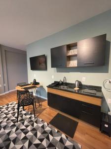 a kitchen with a stove and a table with a tableablish at Residencial Zoe 102 in Foz do Iguaçu +3 photos