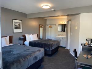 a hotel room with two beds and a bathroom at Monashee Lodge in Revelstoke