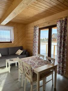 a living room with a table and a couch at Domek Pod Tatrami - Koniówka, blisko Term Chochołowskich in Koniówka