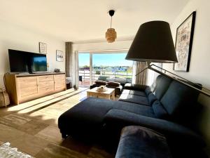a living room with a blue couch and a television at Fewo Körbecke am Möhnesee in Möhnesee