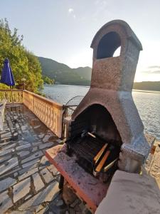 a large stone oven next to a body of water at Vintage house Jablanica Lake in Železnička Stanica Jablanica Grad