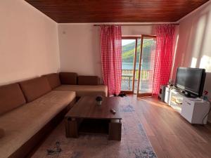 a living room with a couch and a tv at Vintage house Jablanica Lake in Železnička Stanica Jablanica Grad