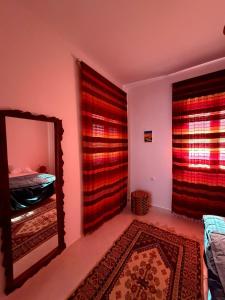 a room with a mirror and a bedroom with a bed at Dar Emna in El Guecheïne +10 photos