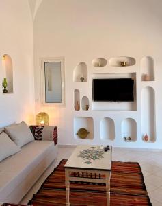 a living room with a couch and a tv at Dar Emna in El Guecheïne