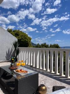 a table with a plate of food on a balcony at Luxury apartment Duće with private pool in Omiš