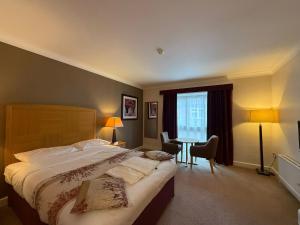 a hotel room with a large bed and a table at Blaby Westfield Hotel in Blaby