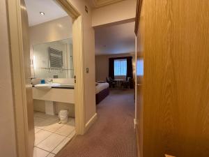 a room with a bathroom with a sink and a mirror at Blaby Westfield Hotel in Blaby