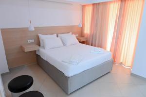 ein kleines Schlafzimmer mit einem weißen Bett und einem Stuhl in der Unterkunft Max Kriti Hotel in Shëngjin + 49 Fotos