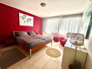 a bedroom with a bed and a red wall at Fewo Körbecke am Möhnesee in Möhnesee