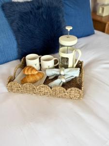 a basket of food and croissants on a bed at Kinkell House in Inverness