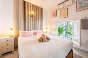 a bedroom with a large white bed with a window at Casa Merlin Capistrano playa in Nerja +41 photos