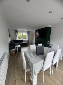 a dining room with a table and white chairs at Central Highland Escape in Caol