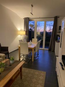a living room with a dining room table and chairs at Moderner Bungalow E25 in Lichtenau