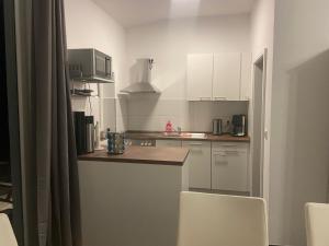 a kitchen with white cabinets and a counter top at Moderner Bungalow E25 in Lichtenau +1 photo