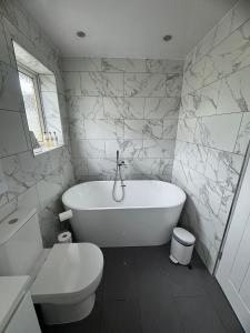a bathroom with a white tub and a toilet at Central Highland Escape in Caol