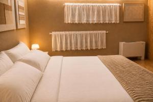 a white bed in a bedroom with a window at Easy Loft Milano in Crescenzago +28 photos