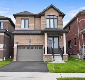 a large brick house with a garage at Spacious 4BR Home with EV Charger in Cambridge