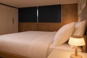 a bedroom with a white bed with a window at Easy Loft Milano in Crescenzago