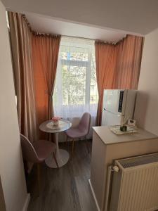 a small kitchen with a table and a refrigerator at Sofia Apartment in Galaţi