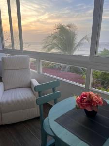 a living room with a chair and a table and a window at Puerto Beach House in Puerto Colombia