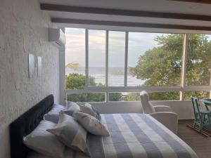 a bedroom with a bed with a view of the ocean at Puerto Beach House in Puerto Colombia