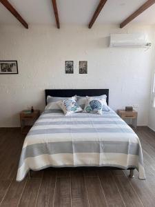 a bedroom with a large bed with two pillows at Puerto Beach House in Puerto Colombia