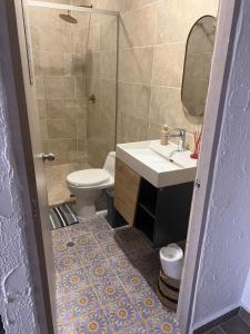 a bathroom with a toilet and a sink and a mirror at Puerto Beach House in Puerto Colombia