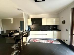 a kitchen with white cabinets and a table with chairs at Ca Rene in Savigliano