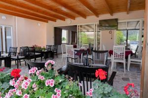 ein Restaurant mit Tischen, Stühlen und Blumen in der Unterkunft Max Kriti Hotel in Shëngjin