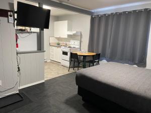 a hotel room with a bed and a table and a kitchen at Monashee Lodge in Revelstoke