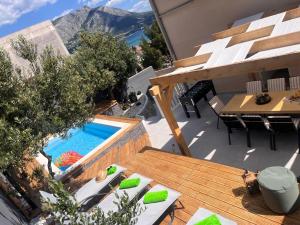 an outdoor patio with a pool and a table and chairs at Luxury apartment Duće with private pool in Omiš
