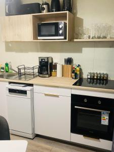 a kitchen with a stove and a microwave at La loge in Marigot