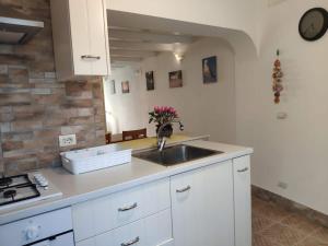 a kitchen with white cabinets and a sink at Casa Arianna in Pellestrina