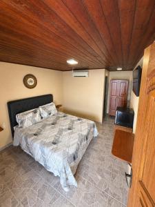 a bedroom with a bed and a wooden ceiling at Pousada Convés - Ilha Grande in Praia de Araçatiba