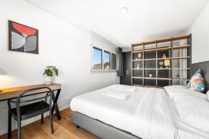 a bedroom with a bed and a desk at Penthouse Exclusif - Grande Terrasse - Avenches - Self Check-in in Avenches