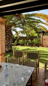a table with two chairs and a table with glasses on it at Luxueuse villa Proche Agadir et Taroudant pour 6 pers Piscine Privée sans vis à vis in Agadir