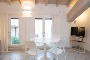 a white dining room with a white table and chairs at Urban Studio Apartment in Brescia
