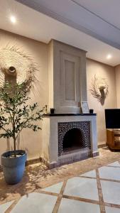 a living room with a fireplace and a plant at Luxueuse villa Proche Agadir et Taroudant pour 6 pers Piscine Privée sans vis à vis in Agadir
