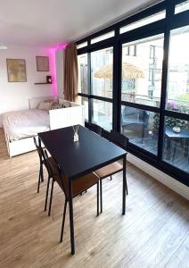 a room with a table and a bed and a bedroom at Large Studio Near Train station and Disney in Lognes