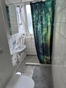a bathroom with a sink and a shower curtain at CityZen Apartment CpH in Copenhagen