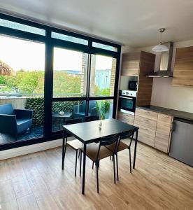 a kitchen with a dining table and a large window at Large Studio Near Train station and Disney in Lognes +5 photos