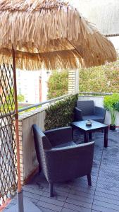 a patio with a table and chairs under a straw umbrella at Large Studio Near Train station and Disney in Lognes