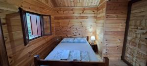 a bedroom in a log cabin with a bed in it at TreeHouse in Bar